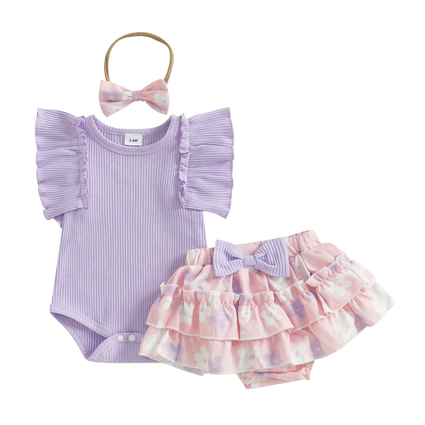 Baby outfit set with purple romper, pink polka dot skirt, and headband on a white background